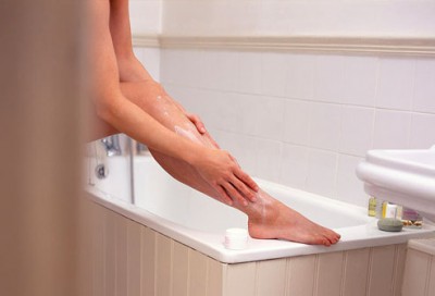 Woman applying lotion after the bath.