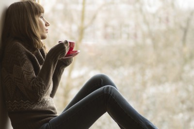 Woman staring out the window in winter.